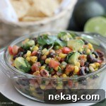 Cowboy Caviar, a chunky salsa-type dip with beans, avocado, tomatoes, corn and a zesty dressing. Great for picnics, potlucks, parties, or a game day snack!