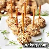 Mini Cheese Ball Bites are studded with dried cranberries and blue cheese, rolled in pecans, and skewered with pretzel sticks for fun, easy party appetizers!
