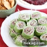 Cranberry Turkey Pinwheels have layers of cream cheese, spicy-sweet cranberry salsa, and thinly sliced turkey all rolled up in a spinach tortilla for a delicious party appetizer! From DessertNowDinnerLater.com