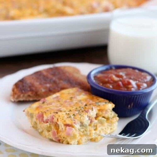 A vibrant close-up of the finished Ham, Green Chile, and Cheese Baked Omelet, showing the golden cheese and colorful ingredients.