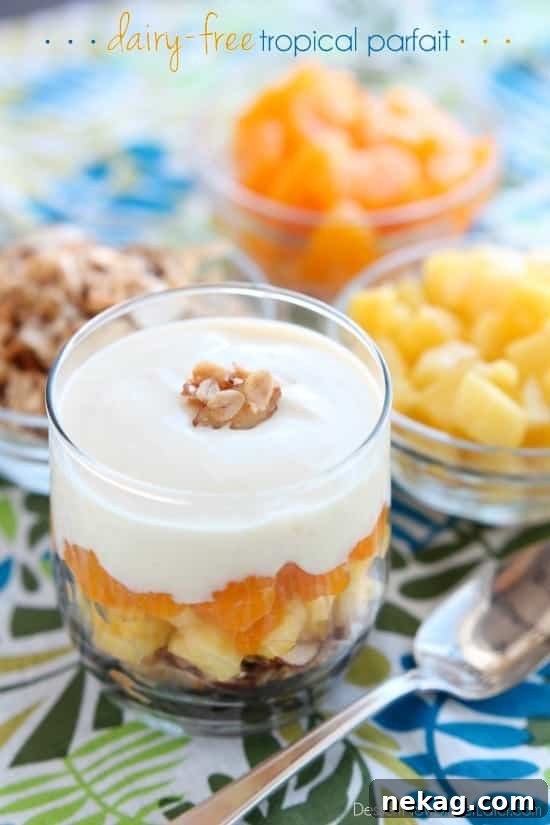 A vibrant close-up of a Dairy-Free Tropical Parfait in a glass, showcasing delicious layers of homemade granola, fresh pineapple, and creamy Silk yogurt alternative.
