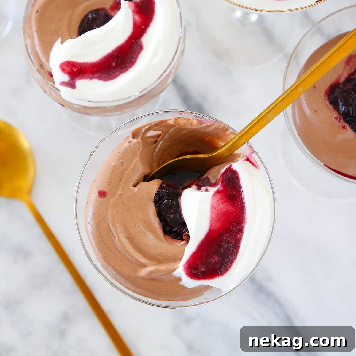 Decadent Chocolate Mousse 2 Chocolate Mousse in glass with gold spoon, topped with whipped cream and a cherry swirl.