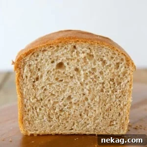 Hearty Whole Wheat Sandwich Loaf 6 A partially cut loaf of whole wheat sandwich bread, showing a soft inside.