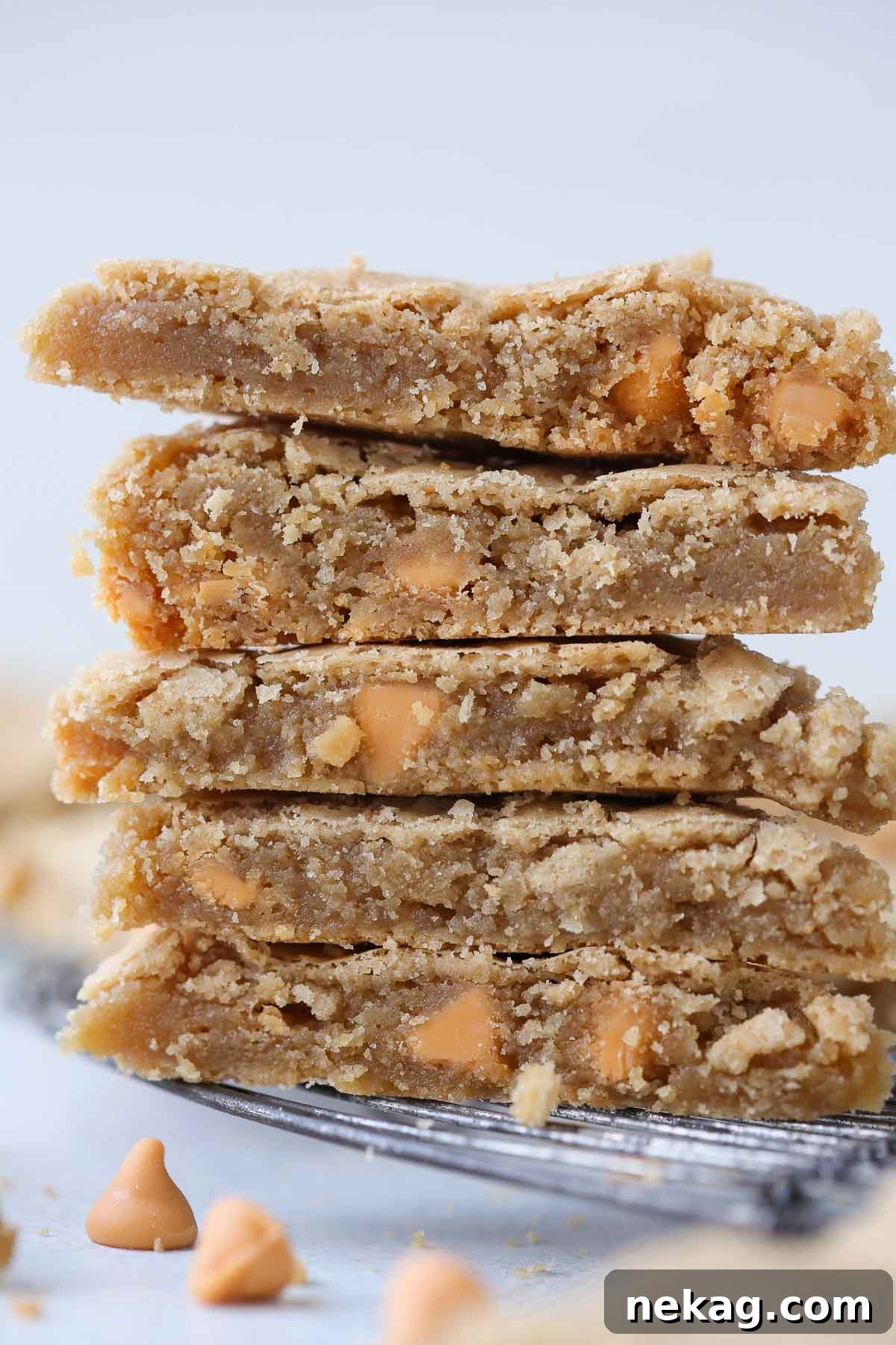 A close-up of a blondie square, revealing abundant butterscotch chips melted throughout the chewy bar.