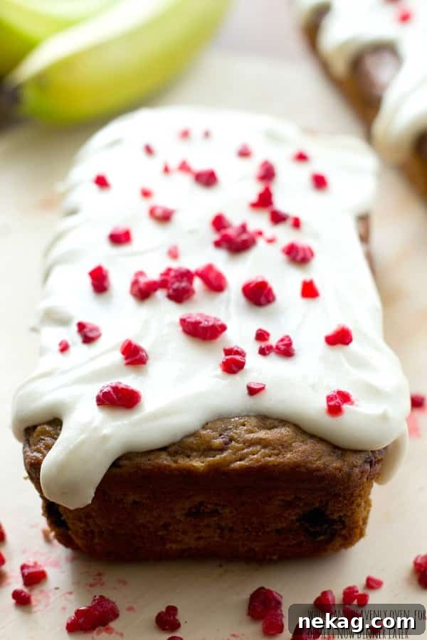 A slice of frosted berry banana bread ready to be enjoyed