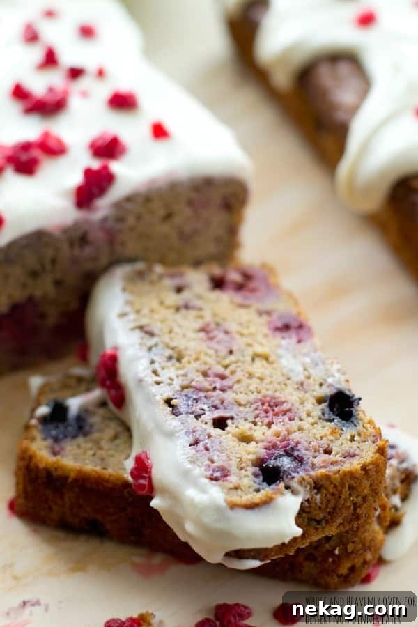 Close-up of a slice of berry banana bread revealing juicy berries