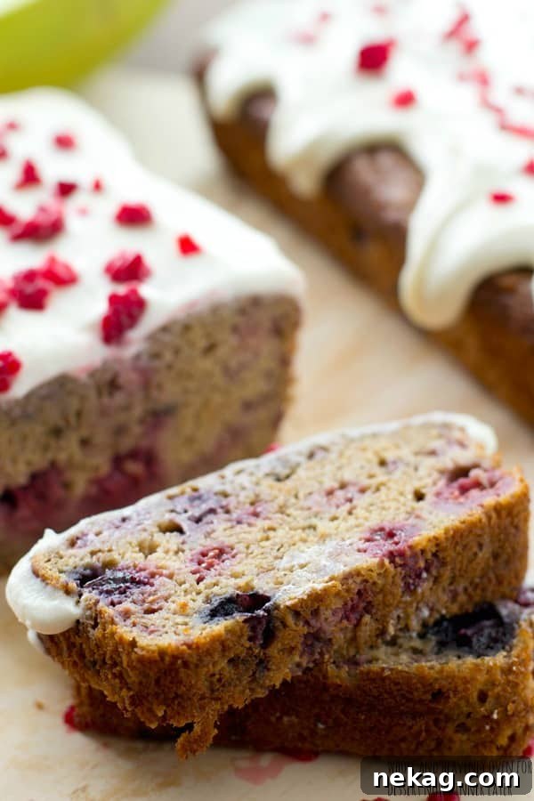 A full loaf of berry banana bread with cream cheese icing, ready to be served