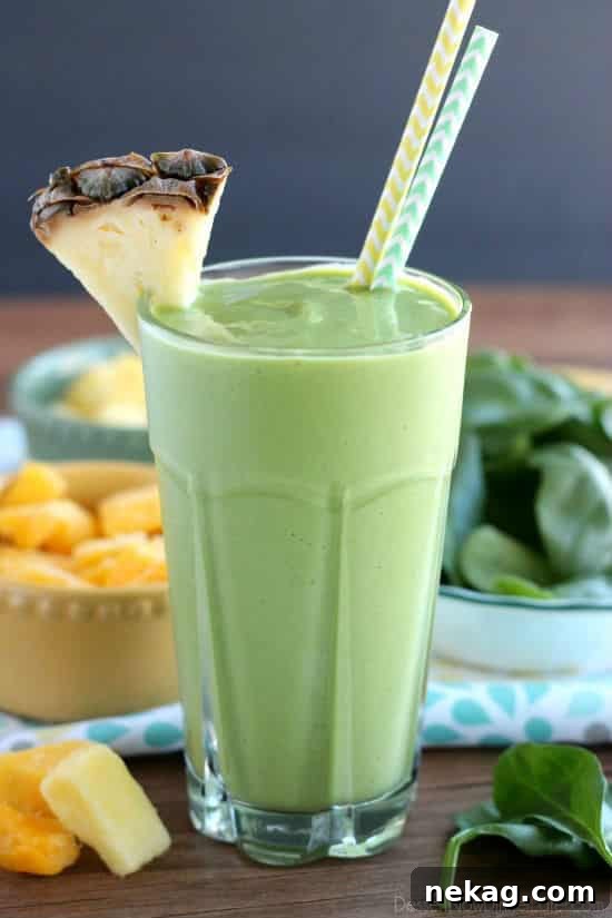 Vibrant Tropical Green Boost 4 A close-up of a refreshing tropical green smoothie in a glass with a straw, emphasizing its smooth and appetizing appearance.