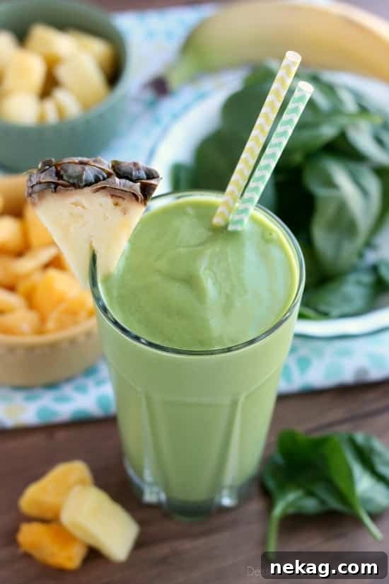 Vibrant Tropical Green Boost 5 Two glasses of tropical green smoothie, with children's hands reaching for them, highlighting its kid-friendly appeal.