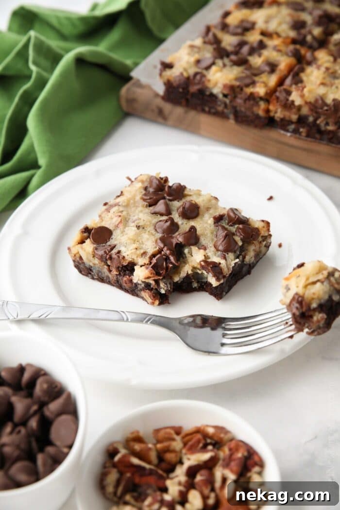 Decadent German Chocolate Bars 4 A fork lifts a bite-sized piece from a German Chocolate Bar, revealing its layered texture of brownie and coconut pecan topping.