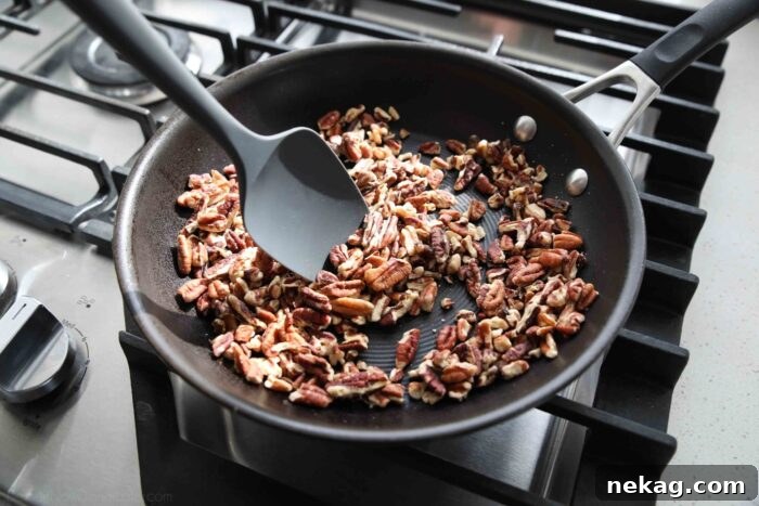 Decadent German Chocolate Bars 6 Chopped pecans being toasted in a dry skillet over medium heat, releasing their aromatic oils.