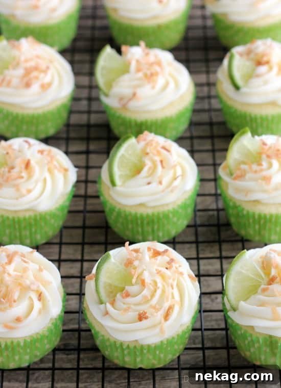 Overhead view of a Coconut Lime Cupcake, highlighting the toasted coconut flakes and lime wedge.