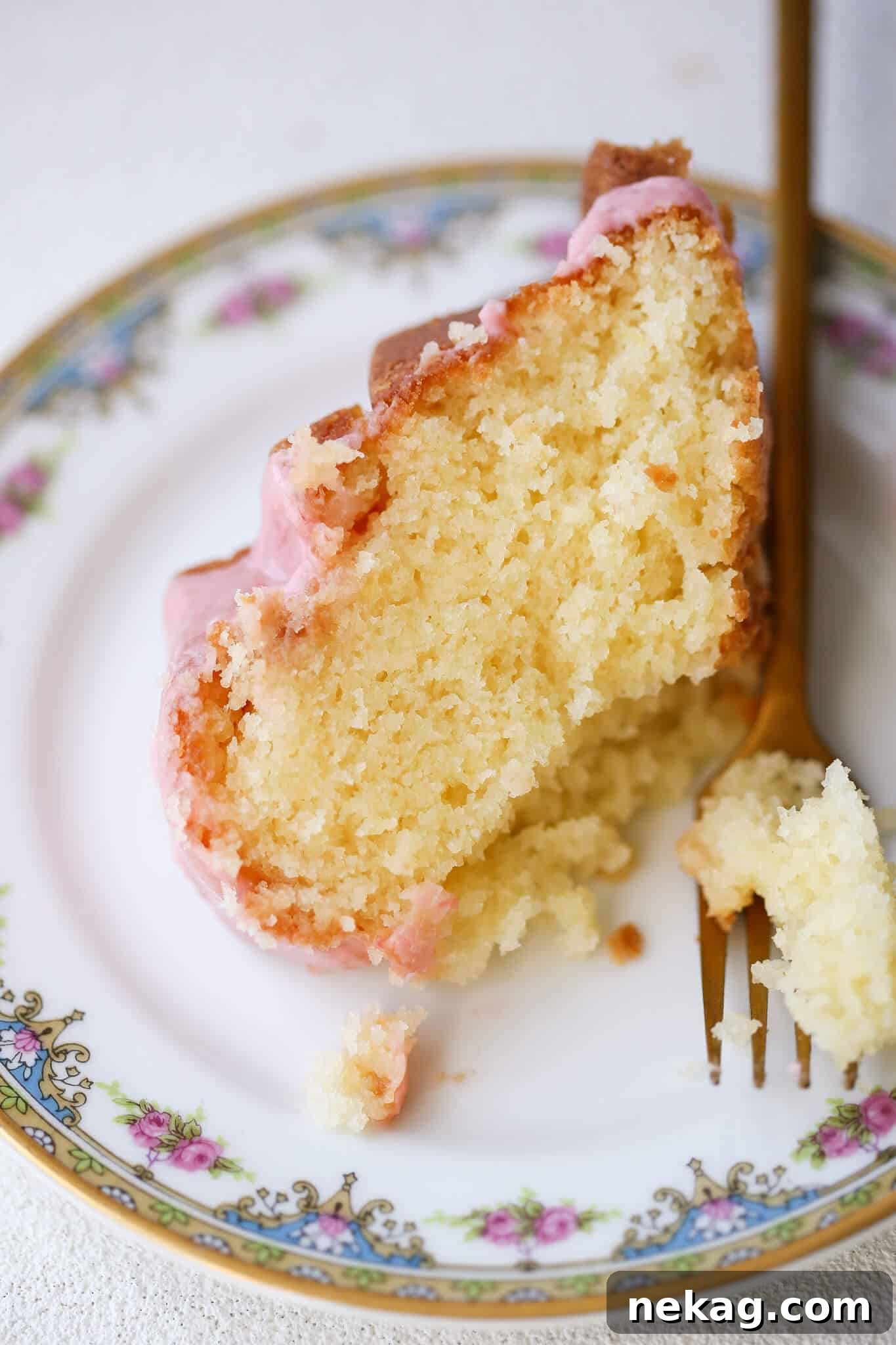 Zesty Lemon Loaf 3 Lemon Pound Cake Strawberry Icing on china plate with gold fork.