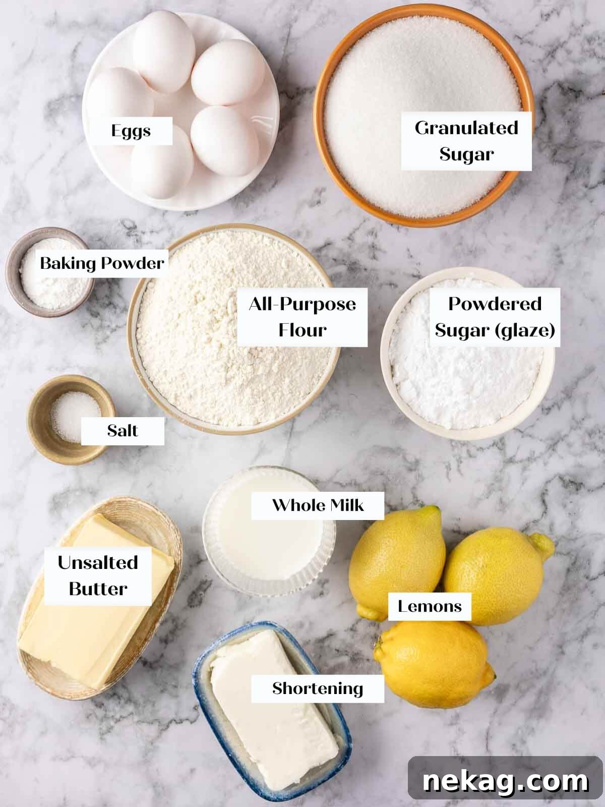 Zesty Lemon Loaf 4 Lemon pound cake ingredients laid out on a white marble countertop.