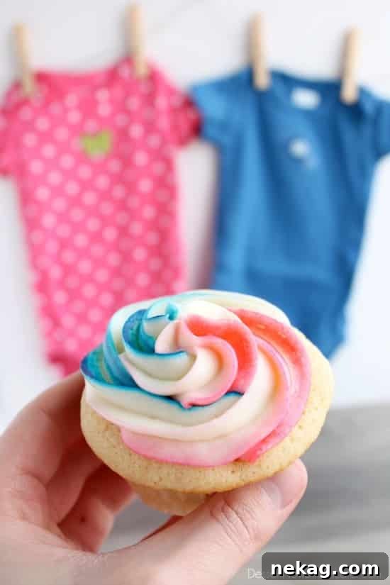 He or She Sweet Bites 2 Gender Reveal Cupcakes with pink, blue, and white swirled frosting, hiding a secret colored heart inside. Perfect for a baby's gender reveal announcement.