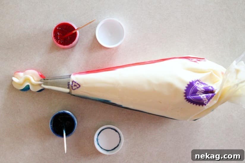 He or She Sweet Bites 9 Piping bag with pink and blue food coloring lines drawn inside, filled with white frosting for a swirled effect.