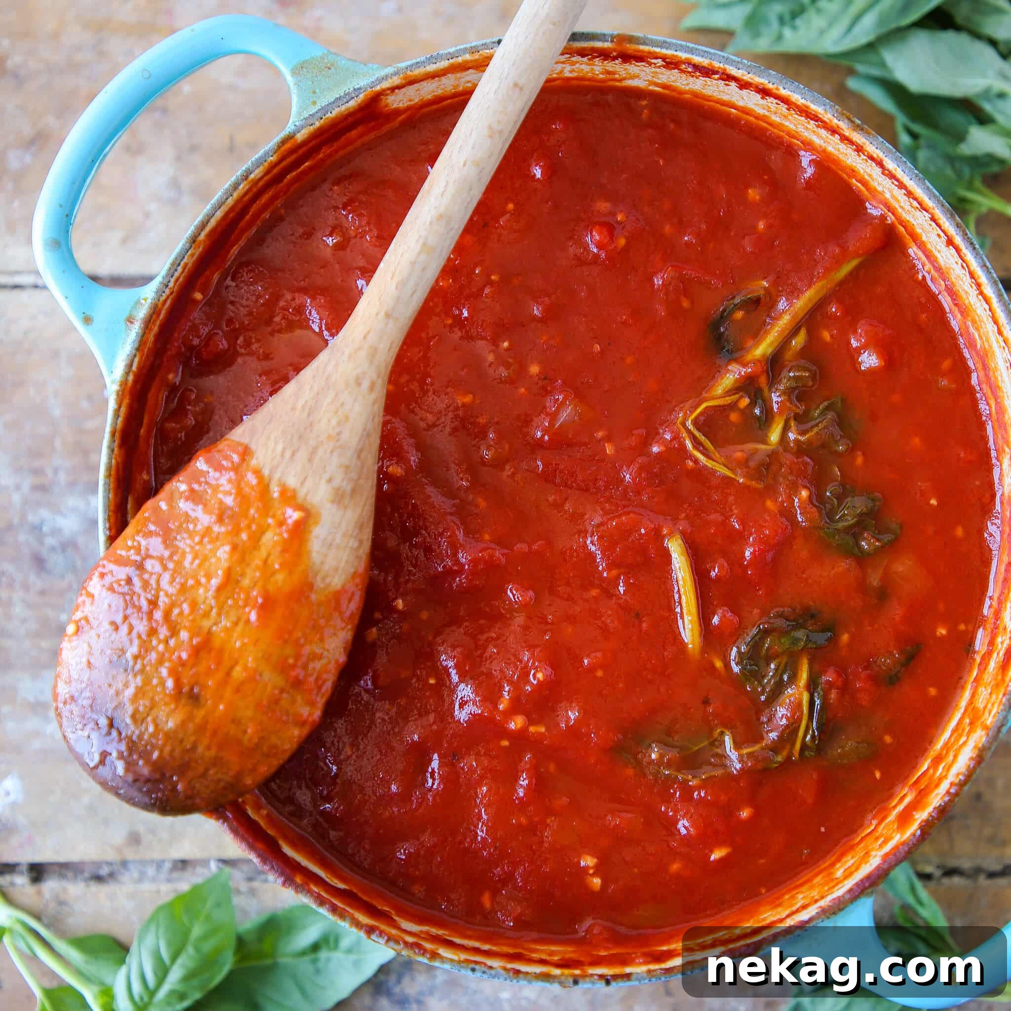Homemade Tomato Pasta Sauce simmering in a rustic blue dutch oven