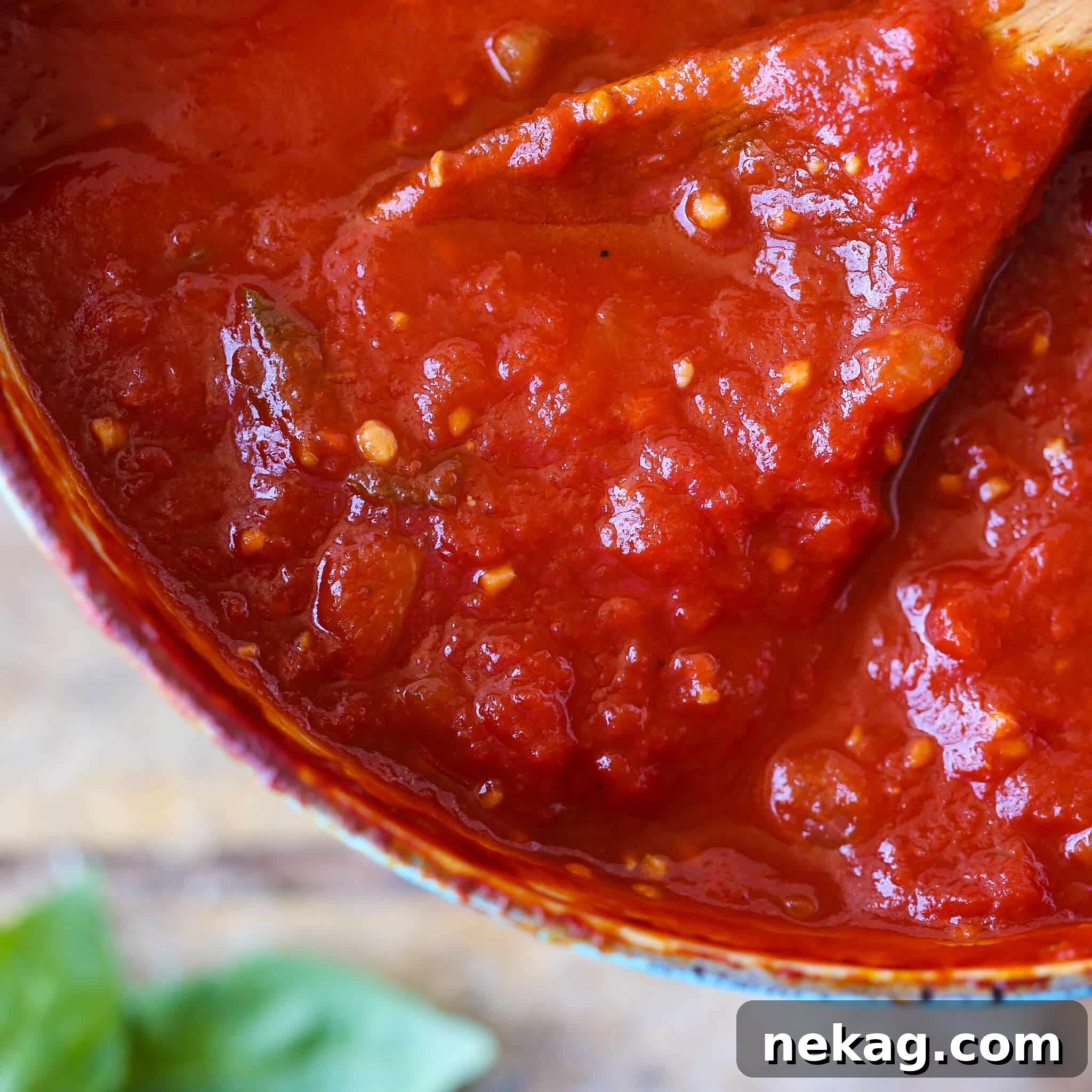 Rich marinara sauce resting on a wooden spoon, ready to be sampled.