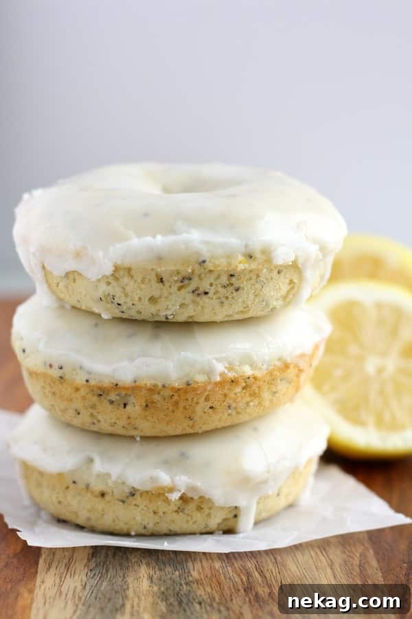 Close-up of a perfectly glazed Baked Lemon Poppy Seed Donut on a cooling rack.