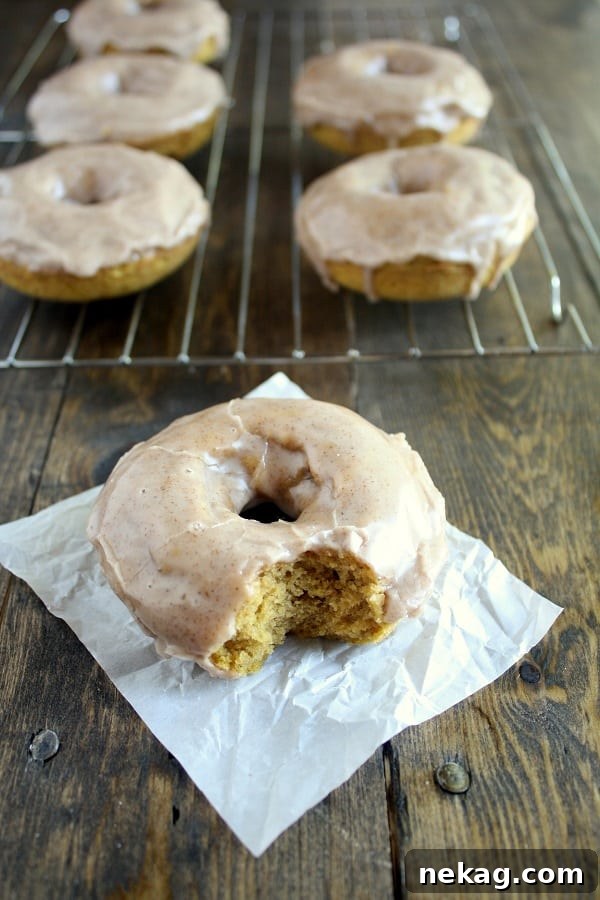 Baked Pumpkin Donuts with Maple Cinnamon Glaze on a cooling rack.