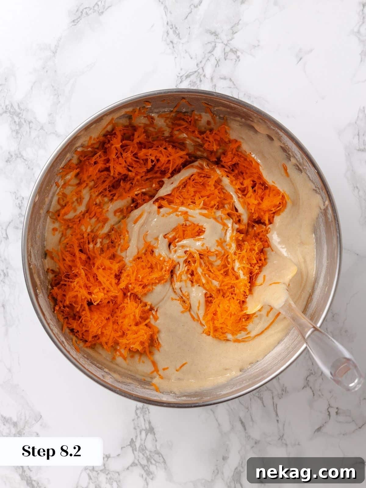 Grated carrots being added to the cake batter.