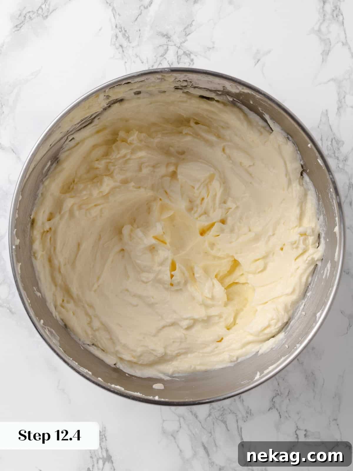 Powdered sugar fully incorporated into the bowl of frosting.