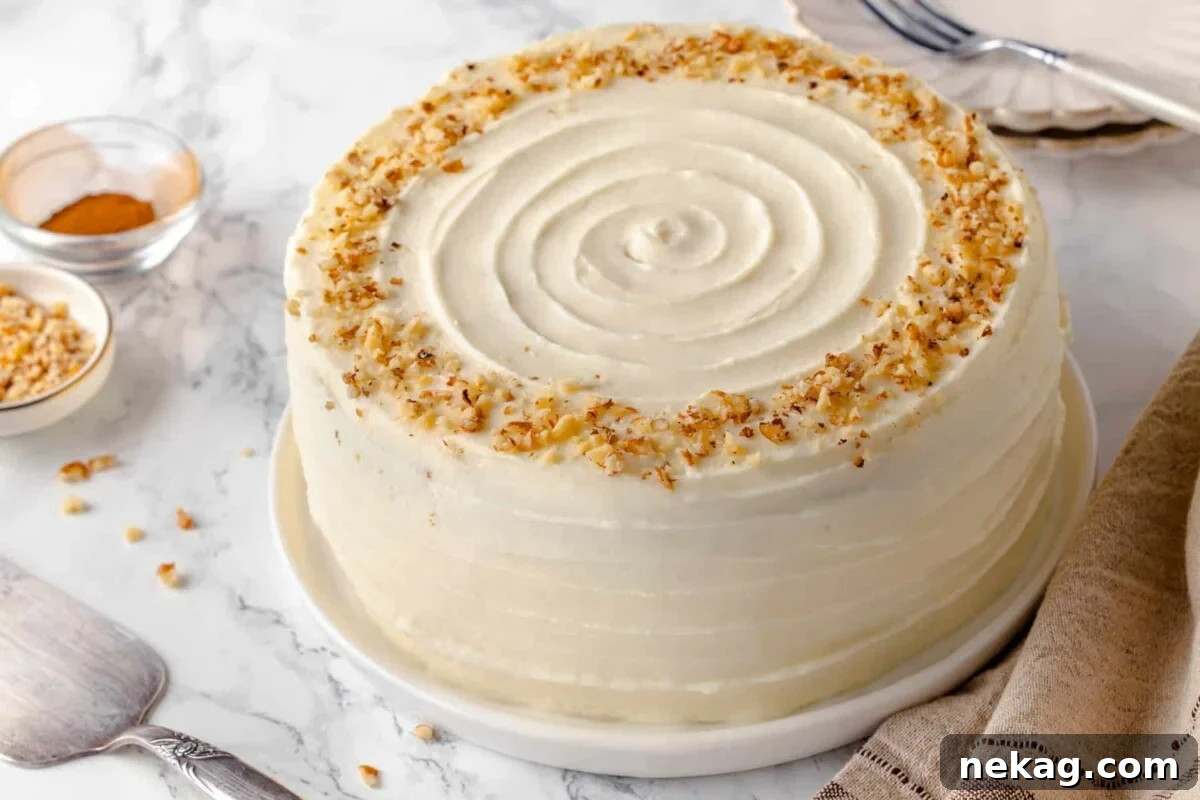 A whole frosted carrot cake with a beautifully swirled top, ready to be served.