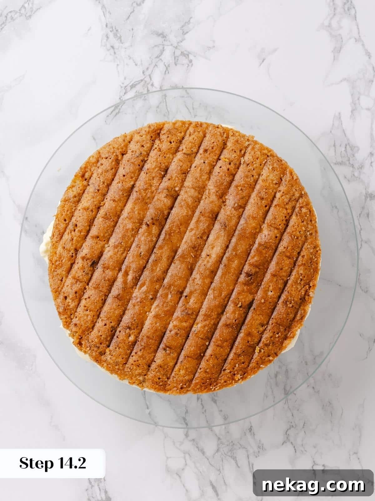 The second unfrosted cake layer carefully placed over the frosted bottom layer.