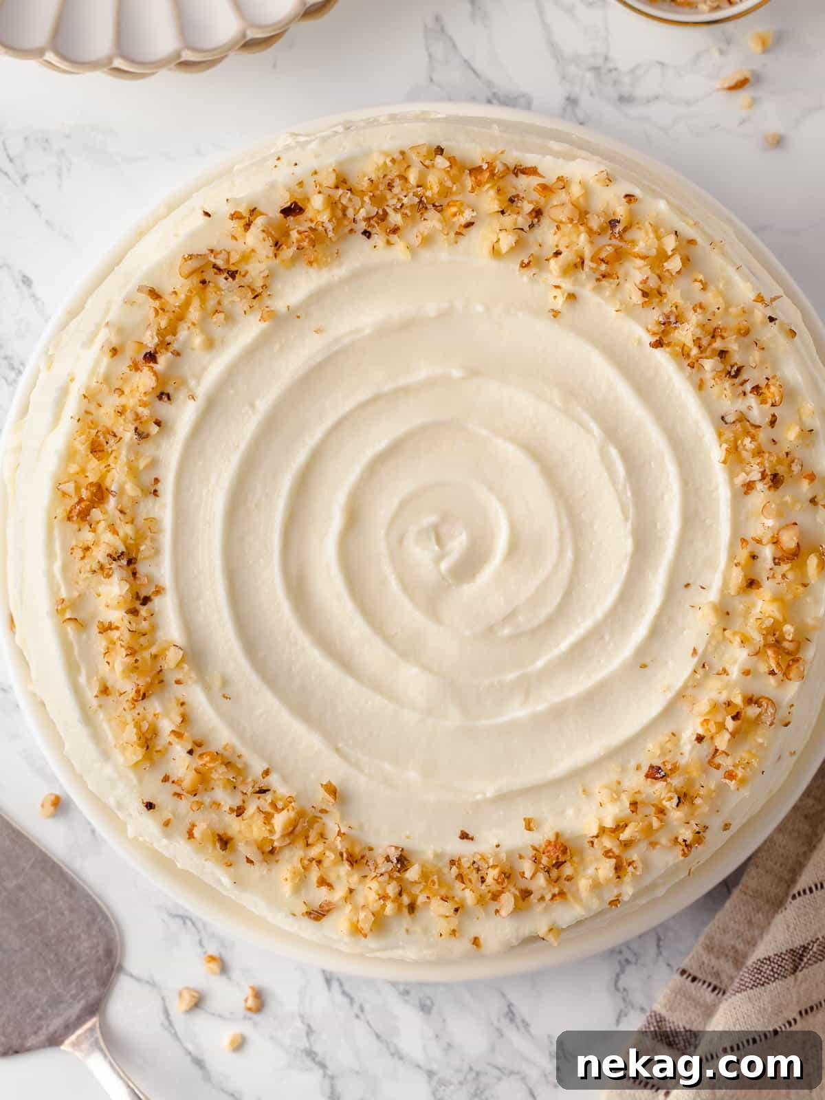 Overhead view of a smoothly frosted carrot cake top, ready for final touches.