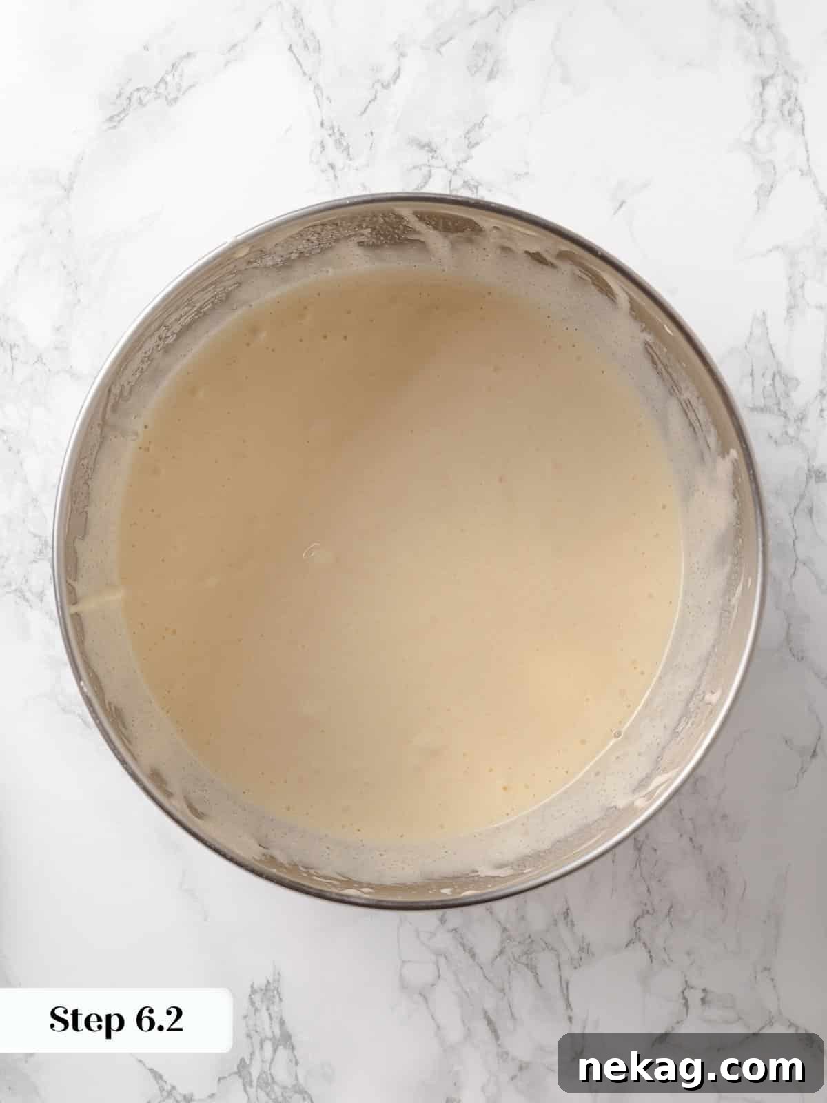Oil mixture being slowly added to the fluffy egg and sugar batter.
