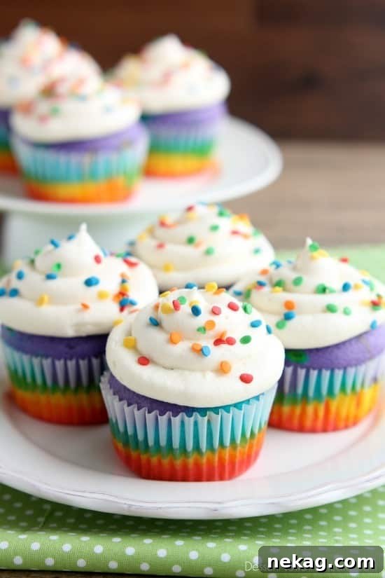These Rainbow Cupcakes are made with a simple boxed white cake mix, colored, and layered to make a rainbow, with whipped cream cheese frosting on top! (Includes photo tutorial, and tips on baking cupcakes to perfection!)