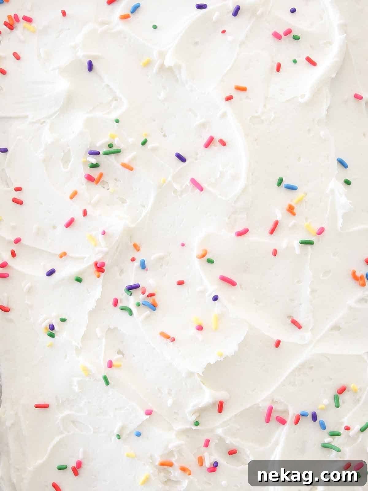Zesty Lemon Buttercream 8 Swirled lemon buttercream frosting with colorful sprinkles on a cake slice, ready to be served.