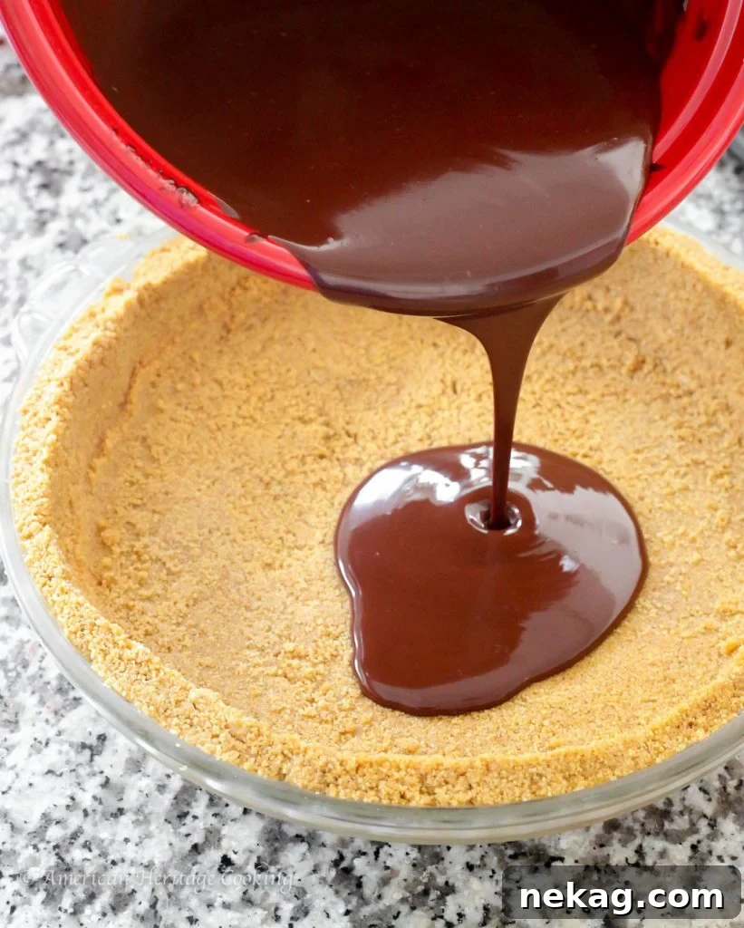 Close-up of golden graham cracker crumbs mixed with melted butter in a bowl, ready to be pressed.