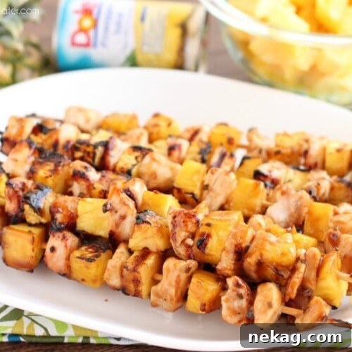 Grilled Island Chicken Skewers with succulent DOLE Pineapple Chunks, glistening with a savory-sweet glaze.
