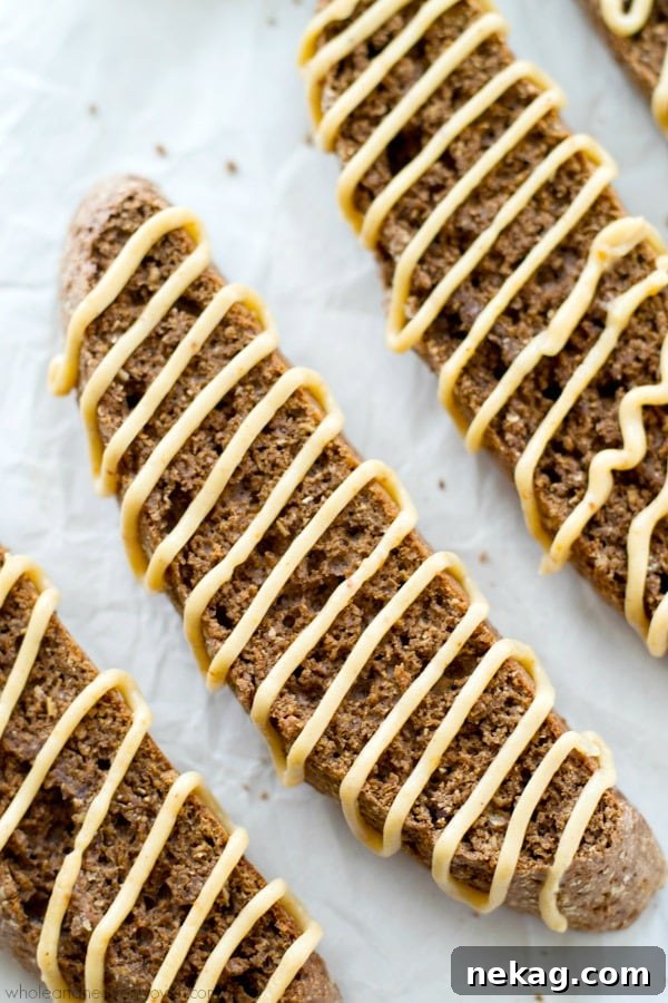 Two pieces of chocolate biscotti with peanut butter glaze next to a cup of coffee.
