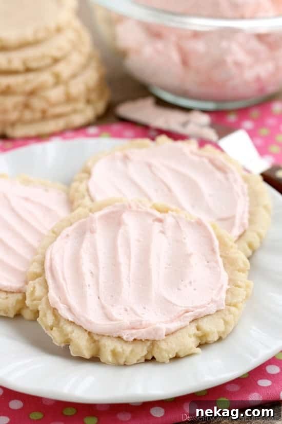 Close-up view of freshly baked sugar cookies, showing their lightly golden edges and soft centers.