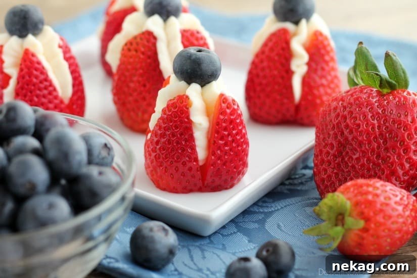 Strawberry Cheesecake Delights 3 Close-up of cheesecake stuffed strawberries, showcasing the creamy filling and fresh blueberry topping.
