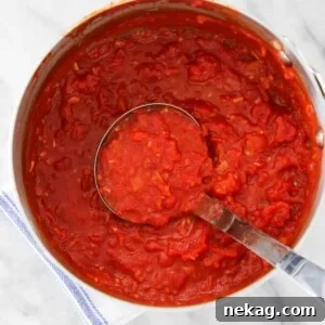 A close-up of a vibrant red 15 Minute Pasta Sauce simmering in a pot.