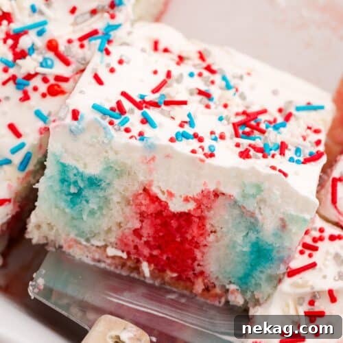 Red white and blue jello poke cake in a pan with a scoop.