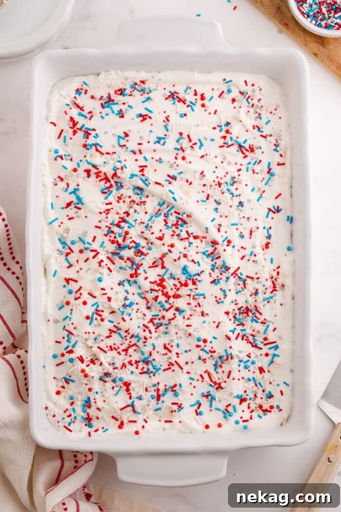 Top view of cake with Cool Whip and red white and blue sprinkles.