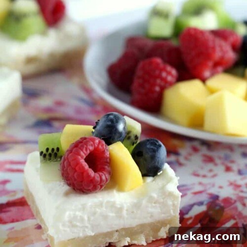 Delicious Fruit Cheesecake Bars topped with fresh berries, kiwi, and mango slices.