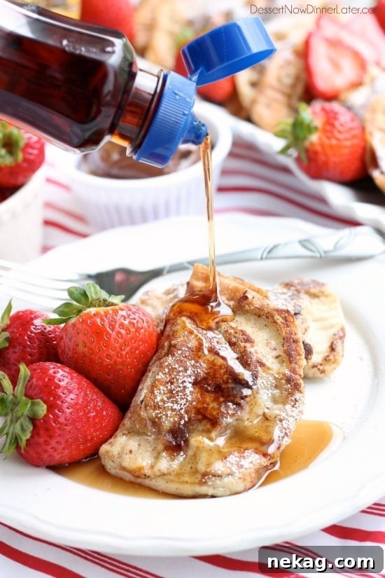 A child's hand gently placing strawberry slices onto bread already spread with Nutella, demonstrating the ease of preparation.