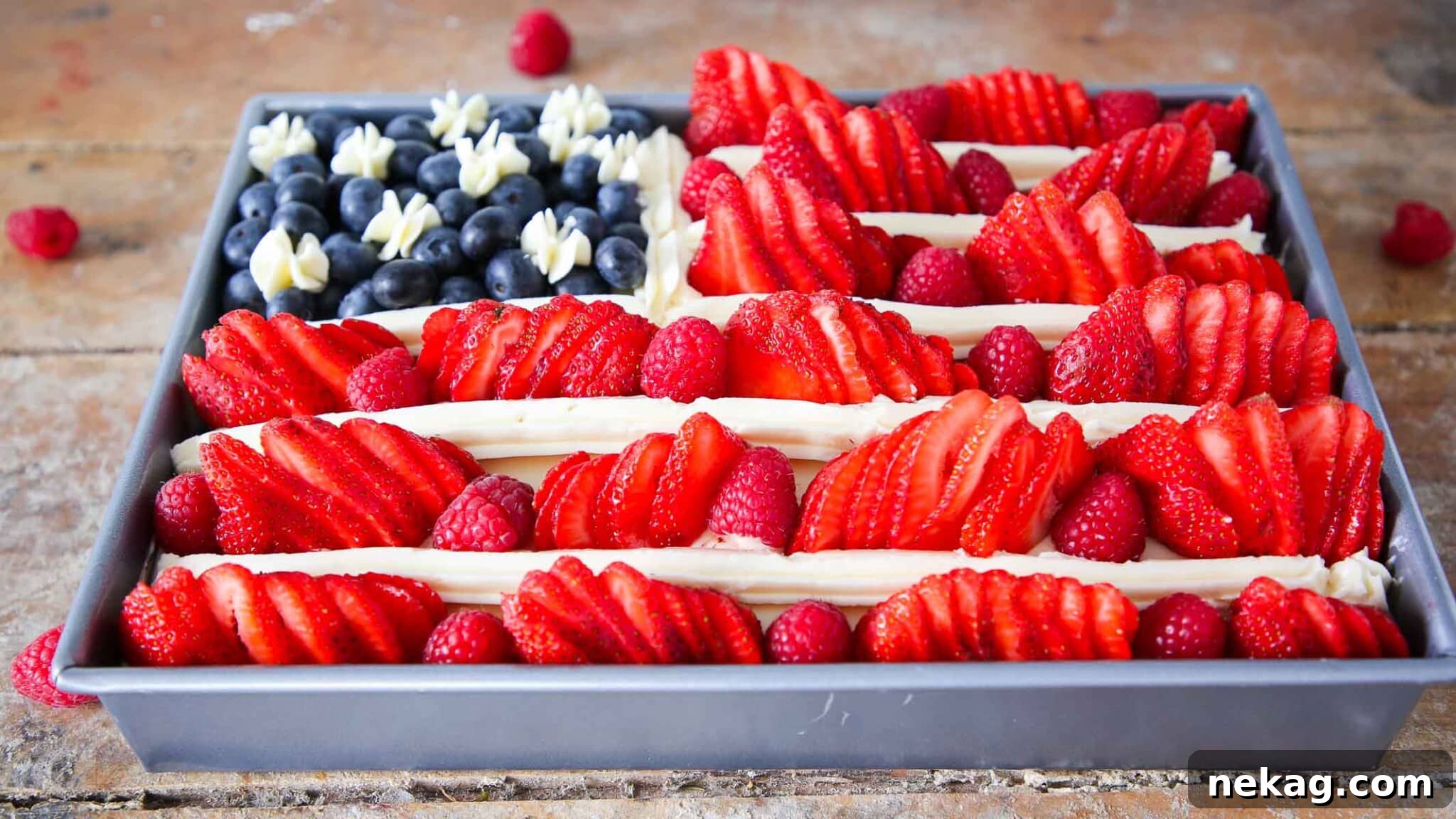american flag cake with berries viewed from the side, showcasing the layers and fresh fruit.