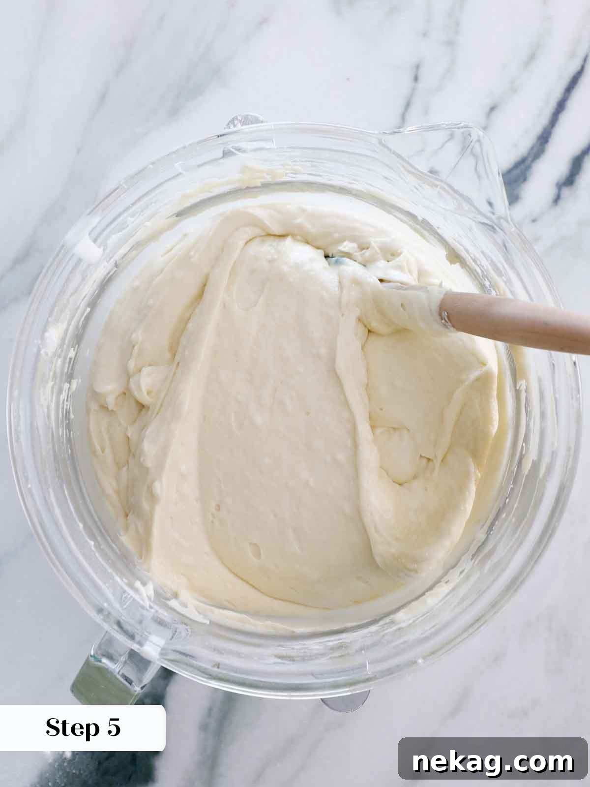 finishing mixing vanilla cake batter with a spatula to ensure no dry spots and prevent overmixing.