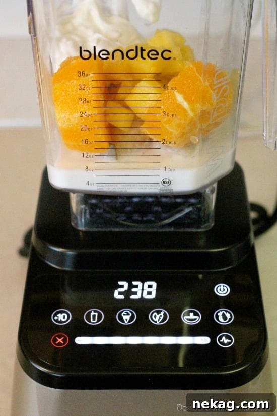 Morning Glow Blend 4 Collection of fresh ingredients for a healthy Sunrise Smoothie including oranges, pineapple chunks, a banana, coconut milk, and Greek yogurt