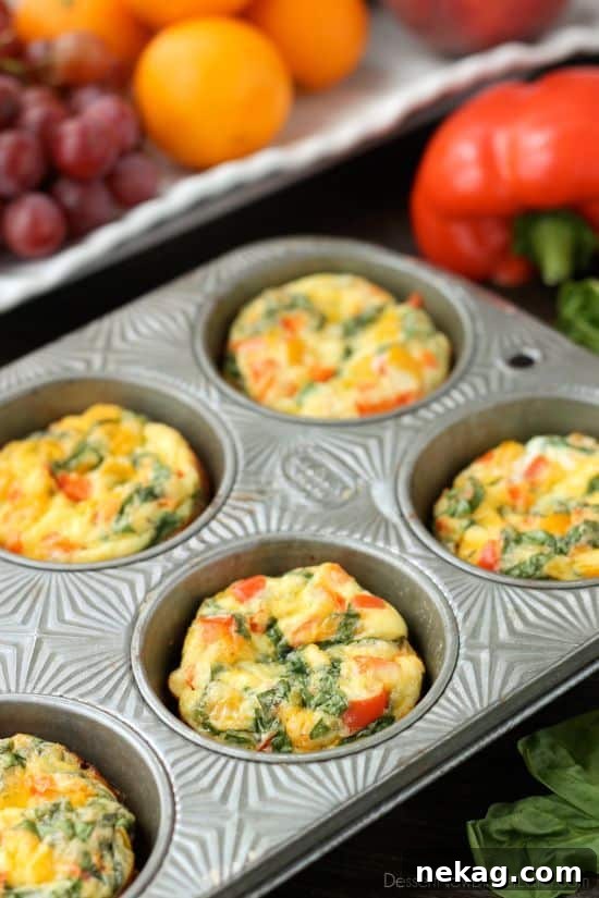 Ingredients for Breakfast Egg Cups laid out on a cutting board, including fresh eggs, bell peppers, spinach, and cheese.