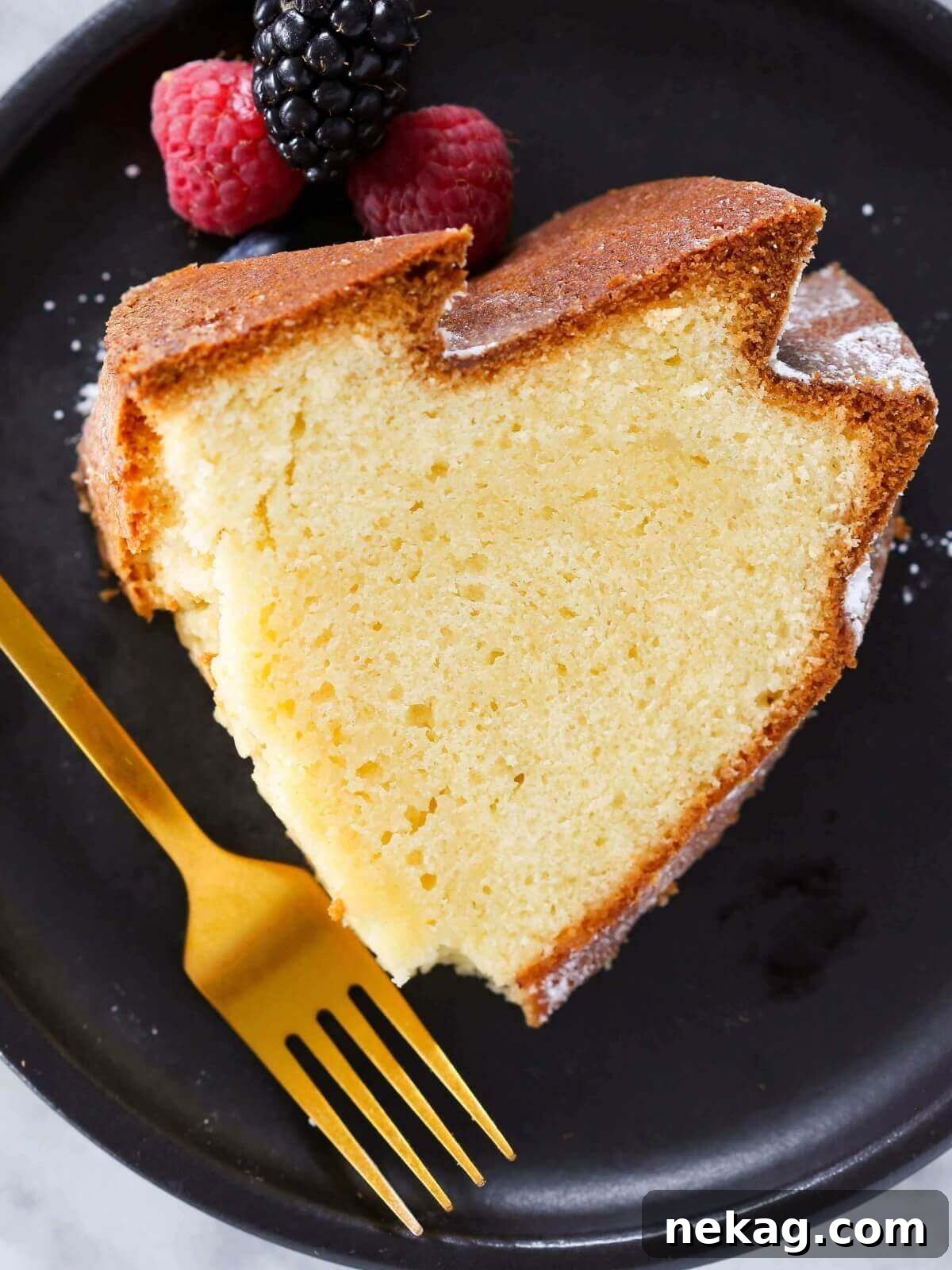 Velvet Sour Cream Pound Cake 2 A perfectly baked Sour Cream Pound Cake, sliced and presented on an elegant black plate, ready to be enjoyed.