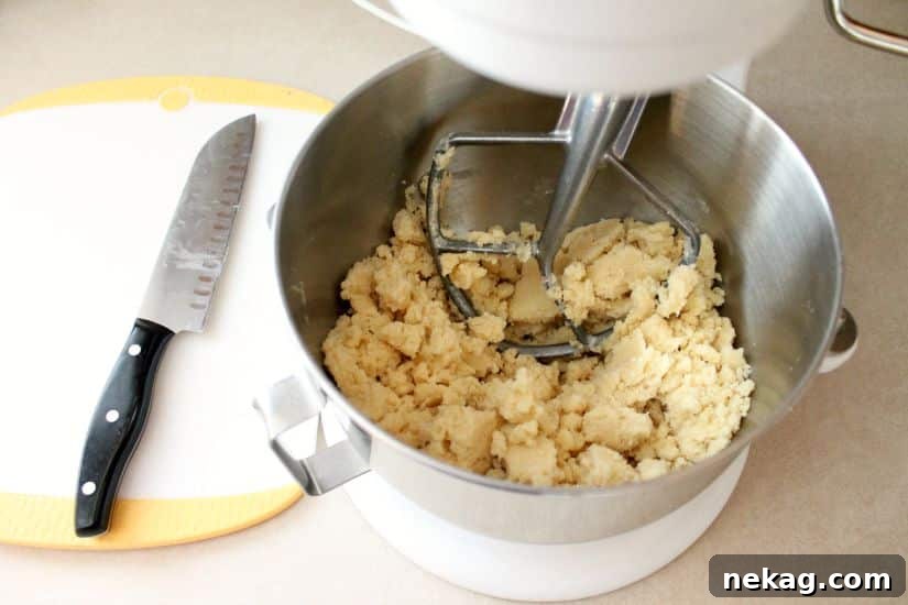 Decadent Chocolate Caramel Apple Crumble Squares 9 Dough coming together in large crumbs after adding the egg.
