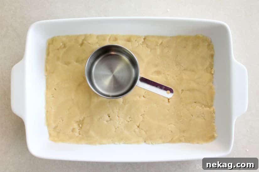 Decadent Chocolate Caramel Apple Crumble Squares 10 Crumb dough pressed into the bottom of a 9x13 inch baking dish.