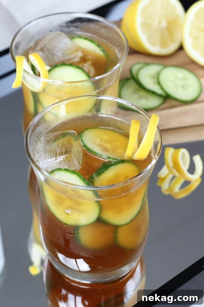 A vibrant Pimm's Cup cocktail with ample ice, cucumber, and lemon slices, ready to be enjoyed.